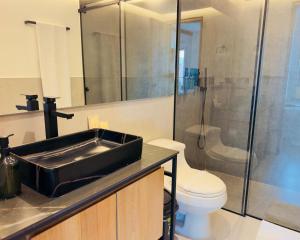 a bathroom with a black sink and a toilet at Hotel Casa Victoria in Medellín