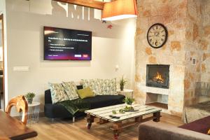 a living room with a couch and a fireplace at A 20 min de Madrid en Ave CASITA con JARDIN PRIVADO, wifi, SMART TV 55p y aparcamiento en la puerta in Segovia