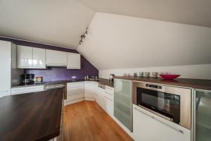 インスブルックにあるBergblick Penthouse Apartmentの白いキャビネットとカウンタートップを備えたキッチン