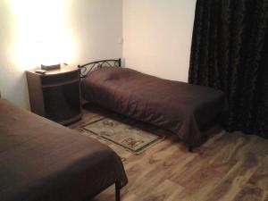 a bedroom with two beds and a desk with a television at Отель Гармония in Dnipro