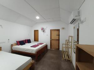 a room with two beds and a staircase in it at Nature Beach Huts in Trincomalee +126 photos