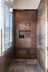 une salle de bain avec une douche avec une porte vitrée dans l'établissement Black Stilt Cottage, luxury stay in Twizel, à Twizel