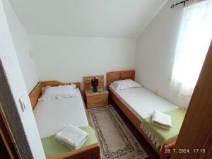 two beds in a small room with a window at Vacation Home "Cehic" in Kulen Vakuf