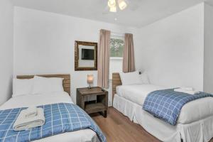 a bedroom with two beds and a mirror and a window at Blue Park Nest - 3BR 2BA in West Columbia