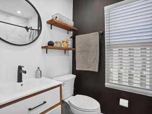 ein Badezimmer mit Toilette, Waschbecken und Spiegel in der Unterkunft Coastal Hideaway in Lake Worth