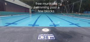 a swimming pool with a sign in front of it at Hostel Metro Floresta Alojamiento in Medellín