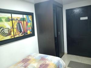 a room with a painting on the wall next to a door at Habitación Independiente El paraíso - Cerca al Gran Malecón del Rio-Barranquilla in Barranquilla