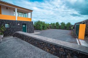 a house with a retaining wall and a driveway at Casa da Vinha in Biscoitos