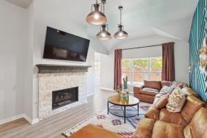 a living room with a couch and a fireplace at 4BD 2BA Saginaw Sanctuary - Pool Firepit Laundry in Saginaw