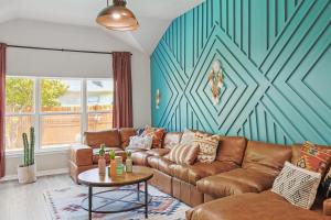 a living room with a brown couch and a blue wall at 4BD 2BA Saginaw Sanctuary - Pool Firepit Laundry in Saginaw