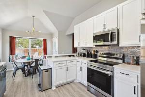 een keuken met witte kasten en een tafel met stoelen bij 4BD 2BA Saginaw Sanctuary - Pool Firepit Laundry in Saginaw