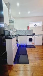 a kitchen with white counters and a washer and dryer at Leeds Kelso in Leeds +24 photos