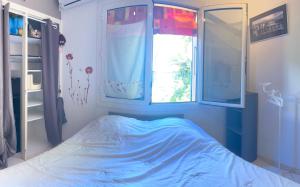 a bedroom with a bed and a window at Maison Les Louves in Saint-Raphaël