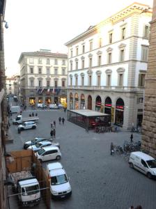 una strada di città con auto parcheggiate di fronte agli edifici di Strozzi Luxury Apartment a Firenze