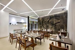 a restaurant with wooden tables and chairs and a mural at Space Hotel and Apartments in Dhaka