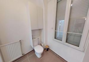 baño blanco con aseo y 2 ventanas en Cozy APT in Le Perreux with Parisian Charm & Disneyland Fun, en Le Perreux-Sur-Marne 15 fotos más