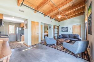 a living room with a couch and chairs and a kitchen at The Crash Pad: An Uncommon Hostel in Chattanooga