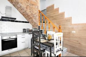 a kitchen with a table with chairs and a staircase at Casa Adela in Barbate +15 photos