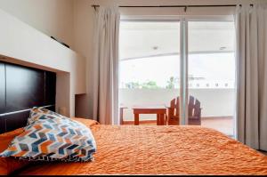een slaapkamer met een bed, een tafel en een raam bij Departamento en centro Cancún in Cancun