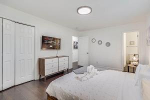 a white bedroom with a bed and a dresser at Spacious Decatur Home Sleeps 12, Work-Ready in Decatur