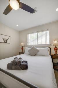 a bedroom with a large white bed with towels on it at Highland Village - 4BR w Backyard Pool Oasis in Highland Village +41 photos