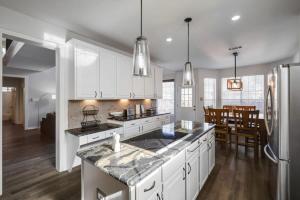 Una cocina con gabinetes blancos y encimera. en Dream Vacay in Central Plano - Pool & Grill, en Plano