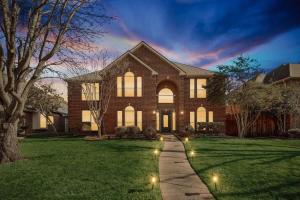 una casa de ladrillo con luces en el patio en Dream Vacay in Central Plano - Pool & Grill, en Plano