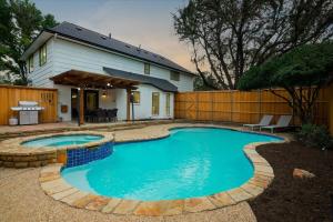 a swimming pool in front of a house at Perfect Getaway Home w 5 Bedrooms & Backyard Oasis in Plano
