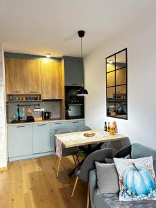 a kitchen and living room with a table and a couch at Apartman Njegoš Lux Titova vila in Palisad