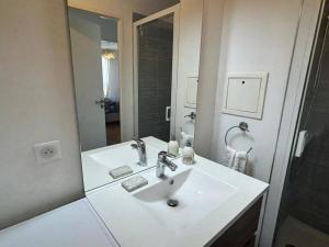 a white bathroom with a sink and a mirror at Le Timbaud, T4 cosy, balcon, parking, aux portes de Paris in Drancy +21 photos