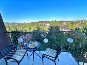 a balcony with two chairs and a table on a balcony at Apartman Njegoš Lux Titova vila in Palisad