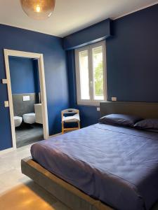 a blue bedroom with a bed and a mirror at Family house by Sarah in Valmadrera