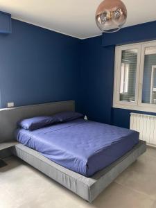 a blue bedroom with a bed with a blue wall at Family house by Sarah in Valmadrera