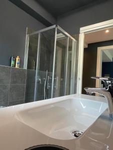 a bathroom with a white sink and a shower at Family house by Sarah in Valmadrera