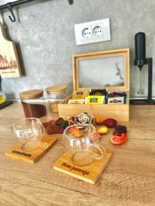 a wooden table with glass bowls of food on it at Apartman Njegoš Lux Titova vila in Palisad