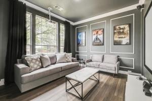 a living room with a couch and a table at Stunning 6BR Pool - Great for Big Groups in Rowlett