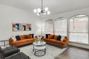 a living room with two couches and a table at Stunning 6BR Pool - Great for Big Groups in Rowlett