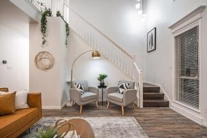 ein Wohnzimmer mit 2 Stühlen und einer Treppe in der Unterkunft Modern and Luxury DFW Mansion with Backyard Oasis in Haltom City