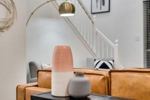ein Wohnzimmer mit einem Sofa und einer Vase auf dem Tisch in der Unterkunft Modern and Luxury DFW Mansion with Backyard Oasis in Haltom City