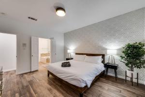 ein Schlafzimmer mit einem großen weißen Bett in einem Zimmer in der Unterkunft Modern and Luxury DFW Mansion with Backyard Oasis in Haltom City