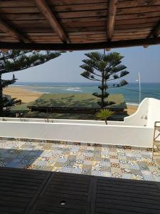 a view of the beach from a patio with a table at KABANO BEACH AUBERGE CAFE RESTAURANT in Moulay Bousselham +18 photos