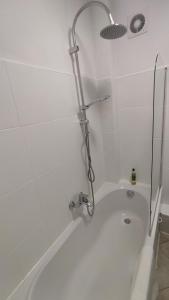 a white bath tub with a shower in a bathroom at Nowogrodzka Central Apartment in Warsaw +20 photos