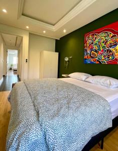 a bedroom with a large bed with a painting on the wall at Emeralds House in Tangier