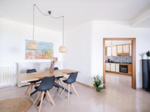a kitchen and dining room with a wooden table and chairs at Villa Moon Total Relax in Alcamo