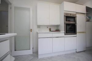 a white kitchen with white cabinets and appliances at Fairview Millport in Millport +53 photos