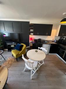 a living room with a table and a yellow couch at Elro House Holiday Let in Tillicoultry