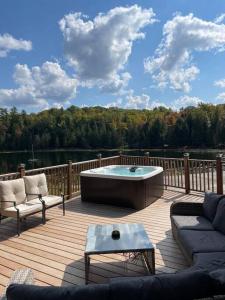 a deck with a hot tub and two chairs and a table at Kings Wee Castle 6BR Serene Luxury Family Retreat in Bancroft