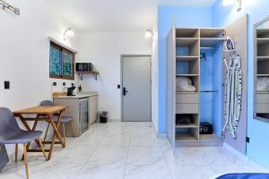 a kitchen with blue walls and a table and a door at Apartaestudios La capital in San José