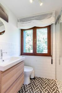 a bathroom with a sink and a toilet and a window at Apartamentos Vista Montaña in Cangas de Onís +118 photos