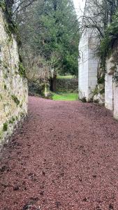 a gravel road next to a stone wall at Villa Maison Roberto in Lerné